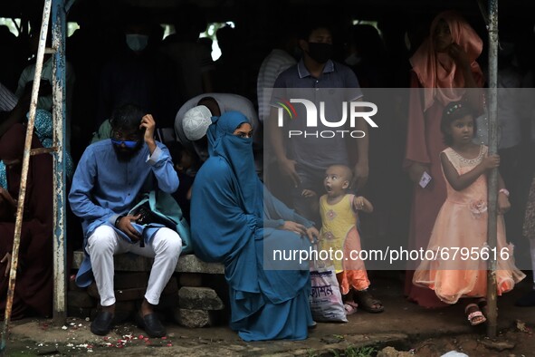 People take shelter during a light rain as they came to visit a park on holiday and cannot maintain social distancing amid the covid-19 pand...