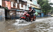 A motorcycle waded through the water logged street in  Kolkata, India, on June 17, 2021. H...