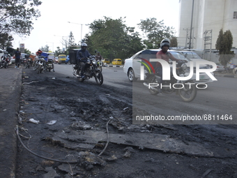 Motorcyclists ride through debris at the scene of a gasoline explosion on Mobolaji Bank Anthony way district of Lagos, on June 18, 2021. A t...