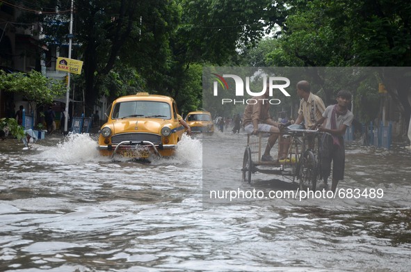 Indian taxi driver and the other  people transports  passengers  in  the waterlogged street due to heavy rain in Kolkata, India on  Friday,...