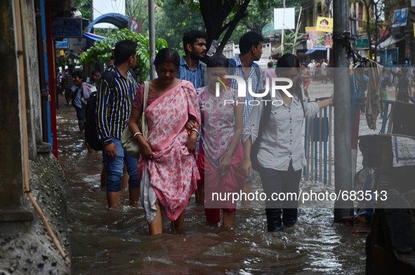 Indian women walking  along  the waterlogged street due to heavy rain in Kolkata, India on  Friday, July 10, 2015. 