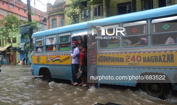 Indian daily passengers  on the way to their work place in a bus  along  the waterlogged street due to heavy rain in Kolkata, India on  Frid...