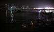 Palestinian youths enjoy a swim in Gaza seaport on a relatively hot night on July 10/11 20...