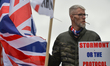 A Loyalist holds a placard with words 'Stormont Or The Protocol?' during a protest against...