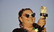 A young girl takes pictures with her cell phone wearing flag-colored glasses on the East R...