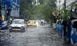A rickshaw puller wades through a flooded street after a heavy rainfall in Kolkata, India,...