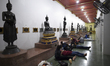 Thai People sleep below Buddha statues as they wait undergo a COVID-19 swab test in Bangko...