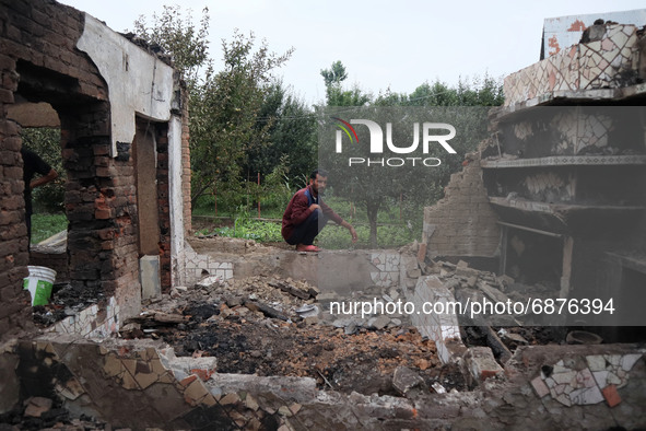 A Kashmiri man sits inside the damaged residential house where three militants were killed in a military operation in Newa area of Pulwama d...