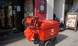 Postman on his round delivering letters & parcels using a "high capacity" trolley in Worth...