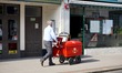 Postman on his round delivering letters & parcels using a "high capacity" trolley in Worth...