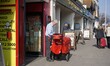 Postman on his round delivering letters & parcels using a "high capacity" trolley in Worth...