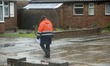 Postman on round in extreme weather conditions of heavy rain