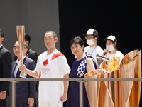 Kabuki actor Nakamura Kankuro (C-L) and Tokyo governor Koike Yuriko (C-R) stand on the stage during the arrival ceremony for the Olympic Tor...