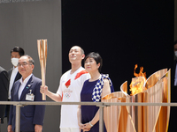 Kabuki actor Nakamura Kankuro (C-L) and Tokyo governor Koike Yuriko (C-R) stand on the stage during the arrival ceremony for the Olympic Tor...
