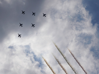The Blue Impulse Japan Air Self-Defense Force aerobatic display team flies over the sky in Shinjuku during the arrival ceremony for the Olym...