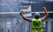 A protester shouts to riot policement while holding a placard "Hisorical protest'. More th...