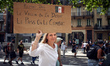 A woman holds a placardreading 'Let's us stay united, Vaccine we can debate, Pass we fight...