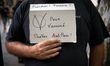 A man shows a cardboard 'V for Vaccinated, Provax, Anti health pass'. reading 'More than 1...