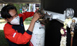 Workers handle free charging oxygen cylinders at the BPBD distribution centre for resident...