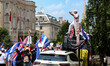 A man stands on top of a vehicle as thousands of demonstrators march from the White House...