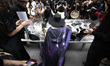 People stop to mourn as artist Anne-Katrin Spiess is carried on 5th Avenue in a clear plas...