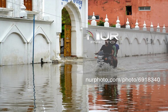 Indian People cross a Flooded street after heavy Monsoon Rains in Pushkar, Rajasthan, India on 31 July 2021.  