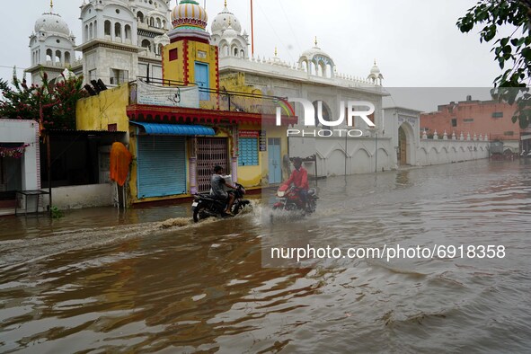 Indian People cross a Flooded street after heavy Monsoon Rains in Pushkar, Rajasthan, India on 31 July 2021.  
