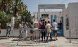 Tunisians queue outside the vaccination centre in the city of Ariana, near the capital Tun...
