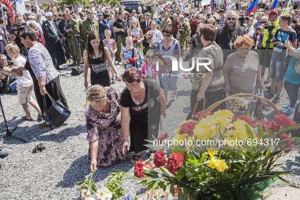 Visitors leave flowers in the stone memorial where the malaysian flight MH17 fell in the Hrabove village, Ukraine, during the celebrations o...