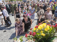 Visitors leave flowers in the stone memorial where the malaysian flight MH17 fell in the Hrabove village, Ukraine, during the celebrations o...