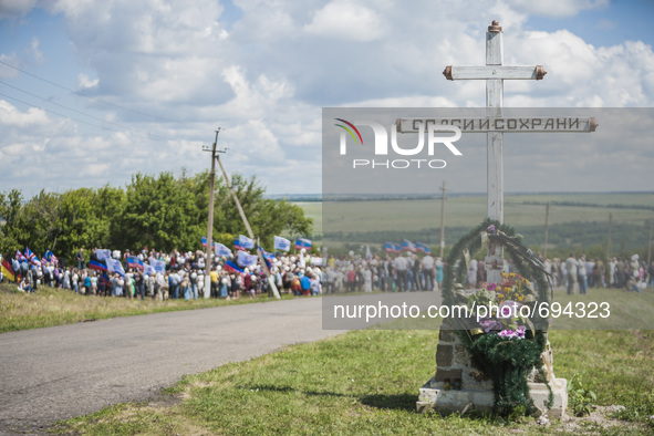 Big cross memorial with a photo of a dead passenger in the place where the malaysian flight MH17 fell after being shot down over the Hradove...