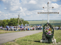 Big cross memorial with a photo of a dead passenger in the place where the malaysian flight MH17 fell after being shot down over the Hradove...