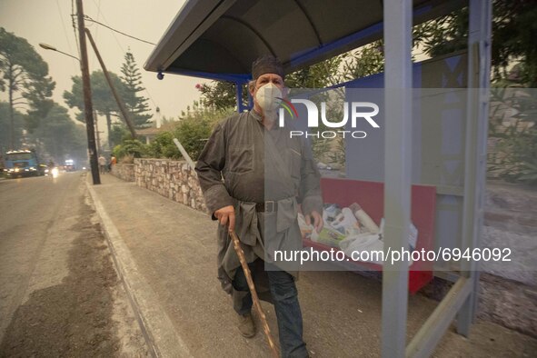 A man walks in the Pefki village, in Evia Island, Greece, on August 8, 2021. The European Union announced that it would be sending aid to Gr...