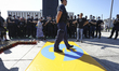 A policeman steps on a banner with the logo of broadcaster TVN modified to resemble a well...