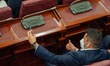 A member of the chamber of representatives use his phone to take a selfie as members of th...