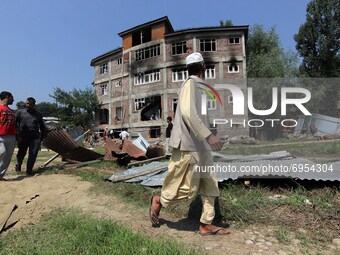 A man looking at the damaged building where according to police a militant was killed in an encounter in south Kashmir's Kulgam area, India...