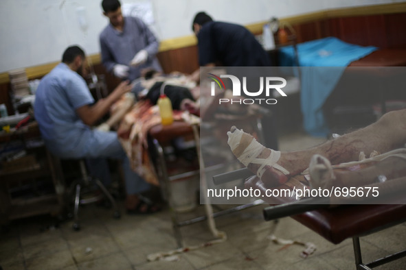 Injured men lie inside a field hospital after what activists said was mortar shelling by forces of Syria's President Bashar al-Assad on Joba...