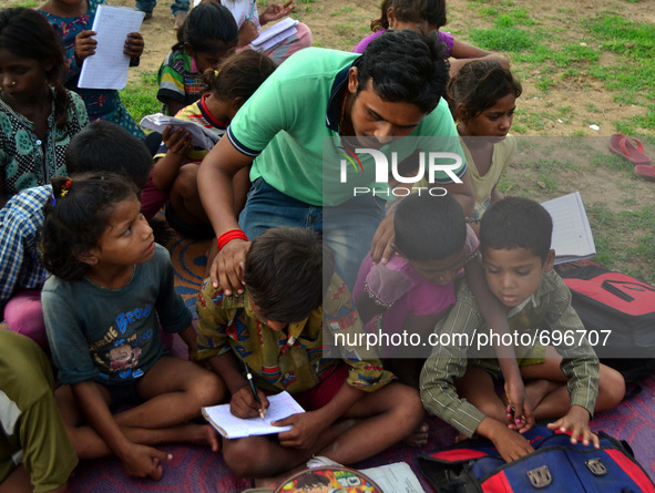An Indian student who prepares for competetive exams,teaches a primary education to children of slums in Allahabad on July 19,2015.They educ...
