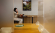 A lady enjoys her breakfast at a coffee shop where partitions are set up on tables to avoi...