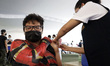A teenager receives the COVID-19 vaccine booster dose of Pfizer administered inside of Xoc...