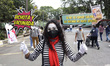 A person  dressed as a mime   holds a placard to invite to be vaccinated against Covid dis...