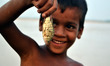 An indian boy shows an alive fish on the river bank of RIver Ganges,in Allahabad on July 2...