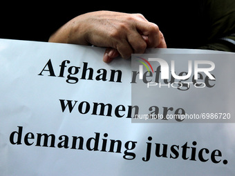 An Afghan woman living in Delhi holds a placard as she participates in a protest appealing international community to come forward to help r...