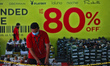 A worker arranges shoes with sale discounts at a shopping mall in Bogor, West Java, Indone...