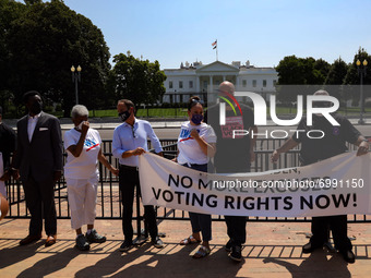 Demonstrators zip-tie their wrists to a fence in front of the White House on August 24, 2021, as part of a civil disobedience protest demand...