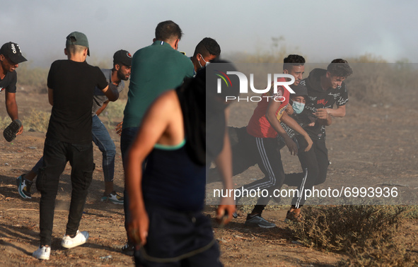 Palestinian protesters carry a wounded young man during a protest in the southern Gaza Strip August 25, 2021. 
 