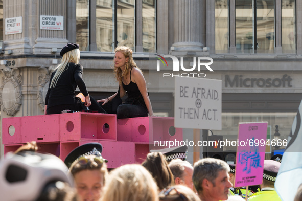 LONDON, UNITED KINGDOM - AUGUST 25, 2021: Environmental activists from Extinction Rebellion are glued to a pink structure blocking Oxford Ci...