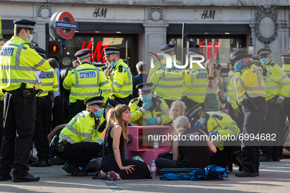 LONDON, UNITED KINGDOM - AUGUST 25, 2021: Police officers speak to environmental activists from Extinction Rebellion who are locked-on in Ox...