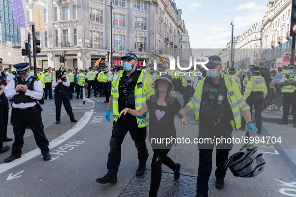 LONDON, UNITED KINGDOM - AUGUST 25, 2021: Police officers arrest an environmental activists from Extinction Rebellion for blocking Oxford Ci...