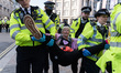 LONDON, UNITED KINGDOM - AUGUST 25, 2021: Police officers carry an environmental activists...